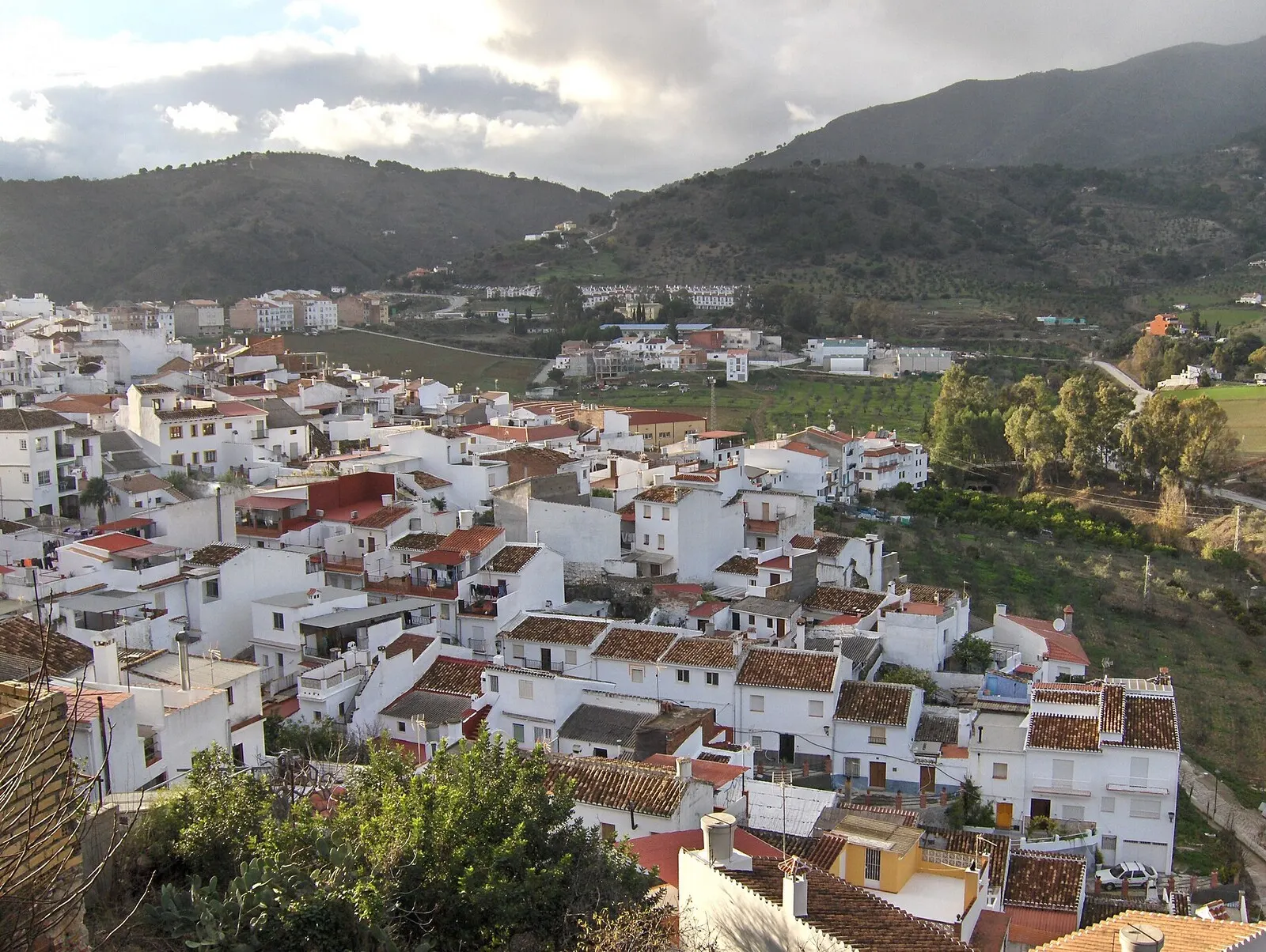 Alozaina, pueblo blanco sobre el valle con la Sierra de las Nieves al fondo